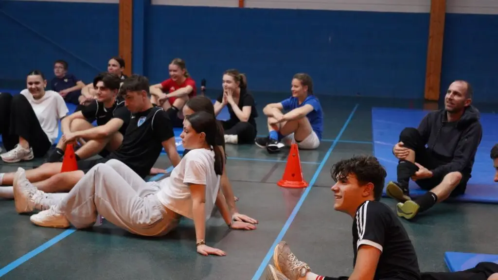 Lycéens de Notre-Dame du Roc assis dans un gymnase pendant un stage de breaking