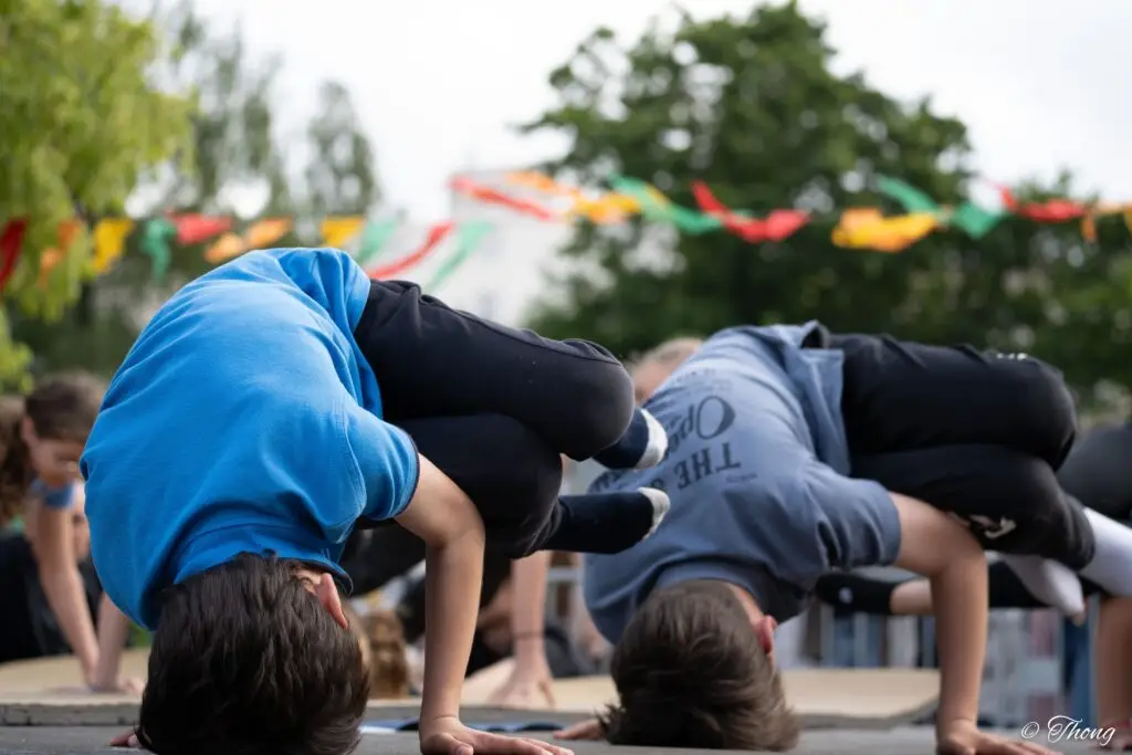 Deux enfants en figure de breakdance au sol pendant un atelier en plein air