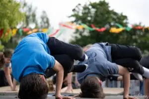 Deux enfants en figure de breakdance au sol pendant un atelier en plein air
